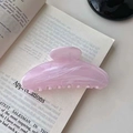 Elegant pink marble textured hair claw clip on book page for stylish hair styling - Pink