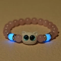 Detailed shot of glowing blue beads and pink tiger eye stone bracelet with owl charm - Rose Quartz