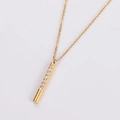 Detailed close-up of golden bar pendant necklace set with seven sparkling cubic zirconia - Gold
