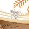 Silver bow stud earring featuring heart and round zircons on a cream tray background - White (Single Piece)