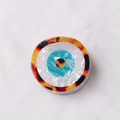 Pinza redonda de acetato con diseño de ojo turco y acabado en carey color ámbar - Carey ámbar / [atributos Del Producto]: Este Producto Parece Ser Un Accesorio Decorativo Redondo Posiblemente Un Componente Para El Cabello O Una Insignia Para Ropa. El Diseño Incorpora El Clásico Elemento Del "ojo Turco". El Material Parece Ser Acetato O Resina Con Un Anillo Exterior Que Presenta Una Textura De Carey (ámbar Y Marrón Oscuro Entretejidos) Un Anillo Interior Con Una Textura Blanca Nacarada Y Un Punto Central Que Forma La Forma De Un Globo Ocular En Azul Cielo Amarillo Y Negro. El Diseño General Exhibe Una Textura En Capas Semitransparente Y Opaca. [presentación Visual]: La Imagen Utiliza Una Composición Centrada Desde Arriba Con El Producto Colocado Plano Sobre Un Fondo De Tela De Sarga Blanca. La Calidad De La Imagen Es [alta] Con Resolución Suficiente Y Enfoque Preciso. El Atractivo Estético Se Califica Como [medio] Con Una Puntuación General De [7.8]. Si Bien La Imagen Es Clara El Fondo Es Demasiado Básico Y Carece De Una Sensación De Alta Gama. [contenido De Texto]: No Hay Información De Texto En Toda La Imagen. [etiqueta Logística]: Ninguna. [riesgo De Infracción]: Este Patrón Es Un Motivo Común Y Ampliamente Utilizado Sin Un Logotipo De Marca Específico; La Probabilidad De Infracción Es De [01]. 【parámetros Del Producto】: La Forma Es Redonda Con Un Diámetro Estimado De 3-5 Cm. El Material Principal Es Ácido Acético/resina.