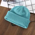 Light blue chunky knit beanie with wide cuff displayed on a stylish wooden table - Light Blue
