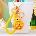 Detail of cute yellow rhinestone duck keychain with gold charm and woven wrist strap - Lucky Yellow Rope + Yellow Pearl Duck