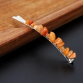 Detail shot of a silver hair clip decorated with vibrant orange natural crystal stones - Orange Moonstone with Silver Clip