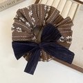 Detalle de coletero de tela con estampado floral y un lazo de pana en azul marino - Floral Marrón con Lazo Azul Oscuro