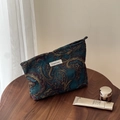 Detailed shot of dark blue paisley jacquard cosmetic bag with gold floral patterns - Jacquard Paisley / Peacock Blue Gold