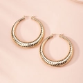 Detailed macro view of gold hoop earrings featuring geometric embossed patterns - Geometric Rhombus Relief Hoop