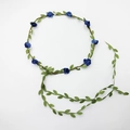 Close-up of a floral headband with blue fabric flowers, green leaves and hanging vines - Royal Blue