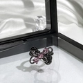 Close-up of black butterfly ring with three pink gemstones on white silk background - Black Metal Pink Gem Bowknot Style (3)