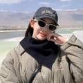 Sciarpa nera alla moda per esterni indossata da una modella con sfondo di lago e montagne - Nero Tinta Unita