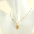 Detail of vintage 18K gold plated oval filigree pendant necklace with white stone center - Retro White Round Plaque / White