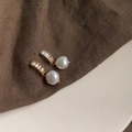 Macro view of Baroque pearl earrings with baguette-cut crystals on brown linen texture - Style 12