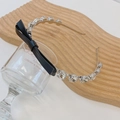 Silver crystal headband with black faux leather bow and rhinestones on wooden tray - Black with Bowknot