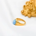 Detailed close-up of an 18k gold plated ring with a natural blue Larimar stone setting - White Blue Veined