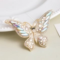 Elegant gold butterfly brooch with shimmering crystals and pearls on white ceramic base - White AB Butterfly