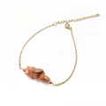 Detalle de piedras naturales rosa irregulares en una cadena ajustable de acero dorado - Cuarzo Fresa