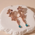 Detalle de pendientes de mariposa con cristales de colores sobre base de piedra blanca - Aguja de Plata Mariposa Oro Rosa