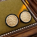 Close-up of golden round stud earrings with black enamel border and wood grain texture detail - Gold/Black