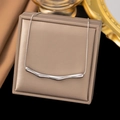 Macro shot of silver curved bar pendant on snake chain inside a premium jewelry box - Pleats / Steel