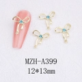 Detail van gouden strik nageldecoratie met blauwe strassteentjes van 12x13mm grootte - Gouden Basis Met Lichtblauwe Strass (A399)