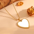 Détail d'un collier pendentif cœur en nacre avec bord perlé sur chaîne à billes dorée - Collier / Collier doré en nacre blanche