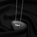 Polished silver Libra zodiac necklace with artistic font on a black pebble background - Libra Steel