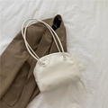 Minimalist cream shoulder bag with slim round straps on an elegant brown blazer - White