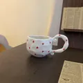 Handcrafted white ceramic coffee mug featuring red heart patterns and a unique spiral handle - Small Hearts Single Mug / Single Cup