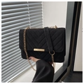 Detail of black suede shoulder bag with V-shaped quilting and gold metal buckle - Black