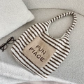Close-up of striped plush tote bag featuring an embroidered front pocket on soft fabric - Brown Striped Tote Style