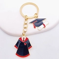 Detail of graduation keychain featuring enamel academic gown and doctoral cap pendants - Black Red Gown Doctor Hat Certificate Style (JE0922A)