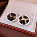 Macro detail of round leopard print earrings with faceted surface in a jewelry box - White Border Leopard