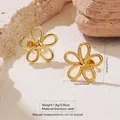 Golden five-petal flower stud earrings made of stainless steel on natural stone surface - Stainless Steel Hollow Five Petal