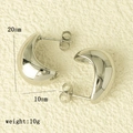 Détail macro des boucles d'oreilles créoles argentées de 20 mm de haut et 10 mm d'épaisseur - Style Poli Miroir / Argenté