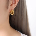 Élégantes boucles d'oreilles doubles créoles dorées avec zircons portées par un mannequin - Doré