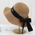 Detailed close-up of a brown straw hat featuring a black ribbon bow and metal logo tag - M (56-58cm) / Coffee
