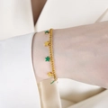 Elegant gold bracelet with green and gold star pendants worn on a female wrist - Bracelet (E435) / 15+5cm / Green