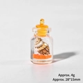 Gros plan du mini pendentif bouteille avec sable orange et coquillage, taille 28x15mm - Bouteille Dérivante Lumineuse (Orange)