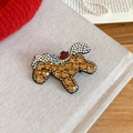 Dettaglio della spilla a forma di cane con cristalli champagne su sfondo rosso a maglia - Fermagli per capelli a becco d'anatra / Stile Barboncino Oro Champagne