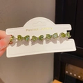 Close-up of green heart-shaped zircon stones on a silver adjustable bracelet chain - 30# Bracelet - Silver - Green - Heart Bow