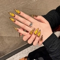 Lange Stiletto Kunstnägel mit goldenem Glitzer Leopard-Muster an der Hand präsentiert - XS / Lange Wassertropfen