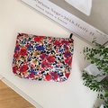 Detailed close-up of floral makeup bag featuring colorful fabric and a woven logo label - Colorful Floral