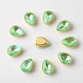 Macro detail of teardrop green rhinestones with gold sew-on base for DIY accessories - 10x14mm / Neon Green AB