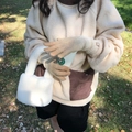 Detail of warm beige knitted gloves and plush handbag in an outdoor autumn setting - Khaki