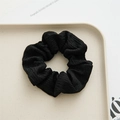 Minimalist black polyester pleated scrunchie with high elasticity on a beige tray - Black