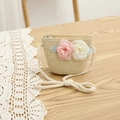 Vue détaillée du sac bandoulière en paille tissée avec de délicates fleurs en mousseline - Sac / Beige