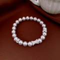 Détail d'un bracelet de perles avec un pendentif nœud argenté sur un tissu marron - Style Nœud Rose (25#)