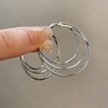 Detail view of silver triple-hoop earrings featuring frosted texture and polished finish - Triple Circle / Silver