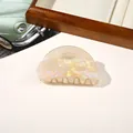 Close-up of a pearlescent semicircular acrylic hair claw clip with aurora shimmer effect - PVC 8cm Round Head - Iridescent Yellow