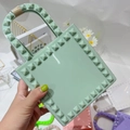 Dettaglio mini borsa in PVC verde menta con trama borchiata e manico avvolto - verde chiaro